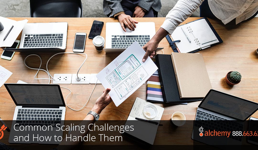 ai_robot_li Team collaborating at a table with laptops, documents, and design sketches, discussing strategies for managing common business scaling challenges.