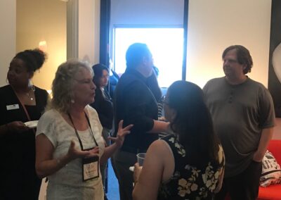 People socializing and networking in an office lounge during a casual business event or open house.