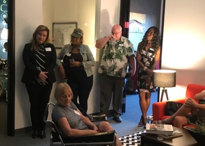 Group of people gathered in an office lounge during a casual meeting or networking event.