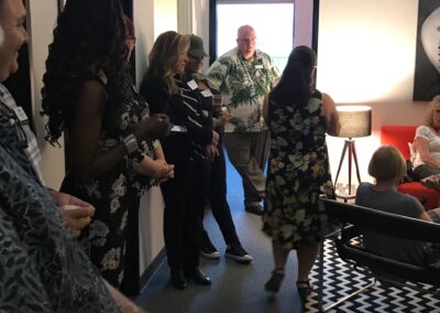Attendees network in the hallway of Alchemy Group’s workspace, showcasing the welcoming and community-driven environment that supports innovation and client engagement.